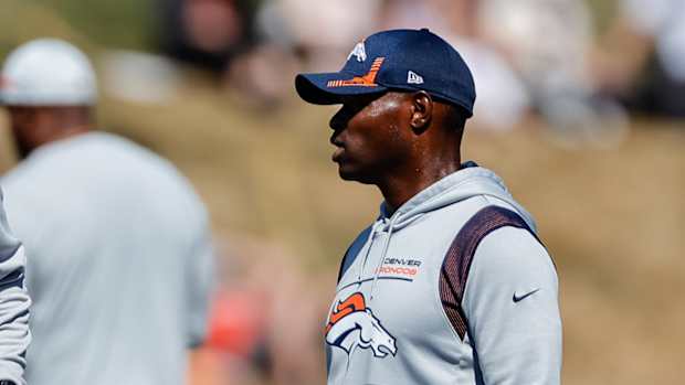 Denver Broncos defensive line coach Marcus Dixon (L) talks with defensive coordinator Ejiro Evero (R) during training camp at the UCHealth Training Center.